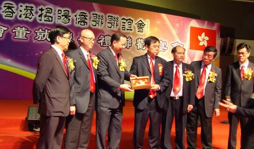 揭东县副县长魏文忠代表揭东县委县政府、香港揭阳侨联联谊会主席邱长喜代表新一届会董，在就职典礼联欢宴会上互赠纪念品。揭东县侨联 供图 