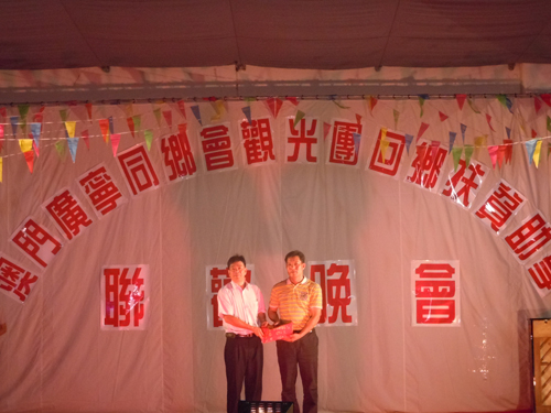 澳门广宁同乡会会长谢锡金（左）在文艺晚会上捐资