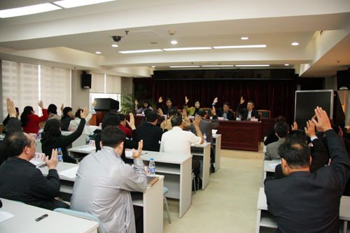 深圳市侨联五届五次常委会上，常委们举手表决有关人事事项。李恩 摄