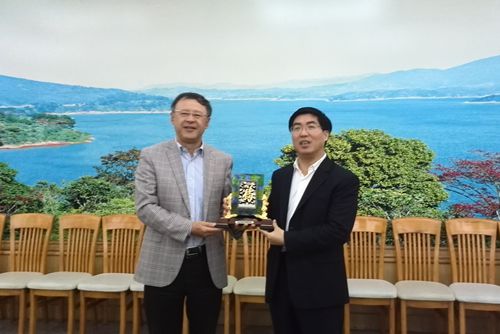 深圳侨商考察团与河源市政府互赠纪念品。