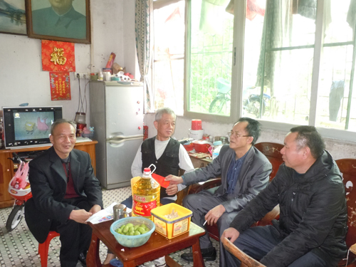 侨联主席江纪华（右3）向老归侨陈永发发放慰问金