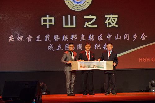 市侨联秘书长（左一）代表市侨联向大会致送纪念品。