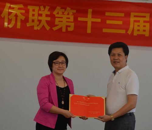 中山市侨联主席余志勇（右）向新当选的梁冬晓（左）副主席
