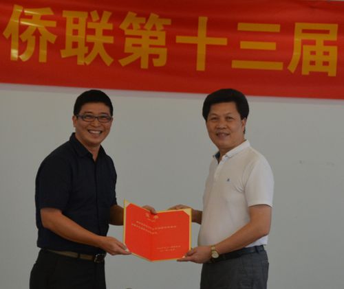中山市侨联主席余志勇（右）向当选的邓洁恒（左）秘书长颁发证书