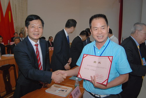 开平市委书记黄耀雄（左）向支持侨务工作先进个人梁卫东（右）颁奖。