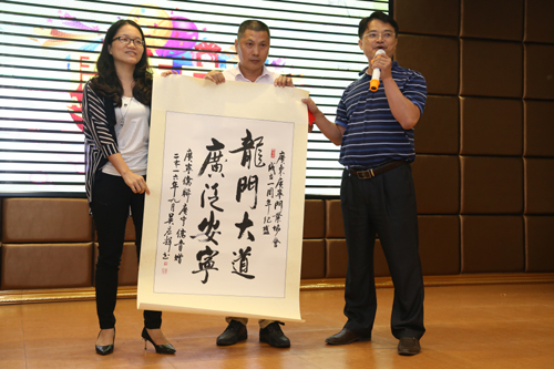 广宁县侨青会会长杨春光（右）、执行会长陈剑勤（左）向门业协会赠送字画