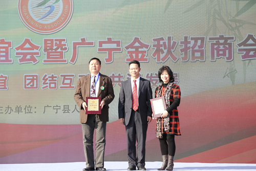 广宁县委书记袁海平（中）向荣誉会长颁发证书