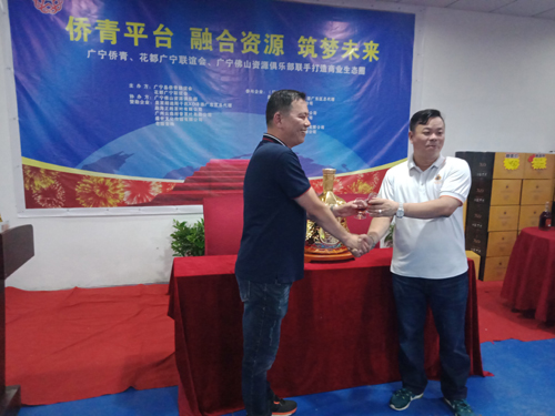 侨青会常务副会长高祖坚与客商互赠纪念品