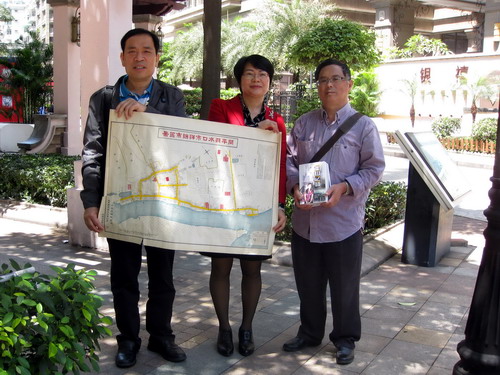 开平市侨联从招铭光先生（右一）手中接过地图及丛书。