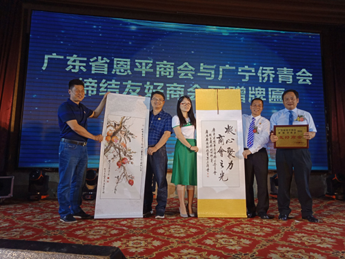 广宁县侨联副主席陈剑勤（左3）、广宁县侨青会会长杨春光（左2）向恩平商会赠送字画