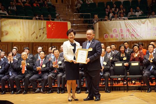 我会名誉主席余国春连任会长，林郑月娥为其颁授会长证书。