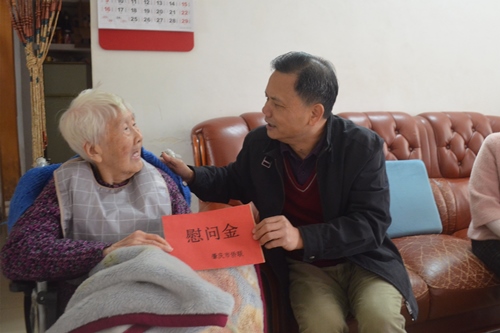 2市侨联一级调研员黄志坚（右）向印尼归侨郭惠英送上慰问金_副本.jpg